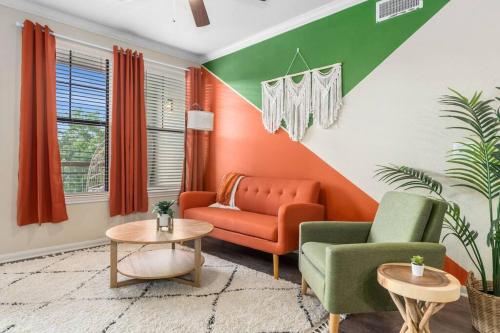 a living room with an orange and green wall at Modish King Bed w/ Pool & Gym in Houston