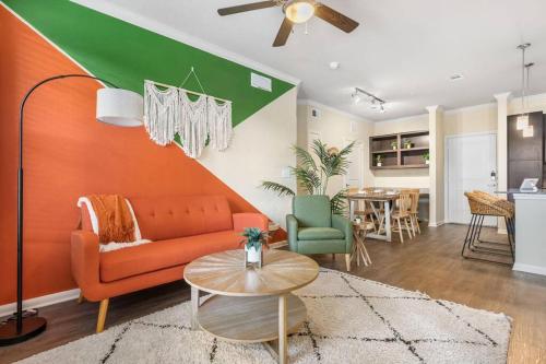 a living room with an orange couch and a table at Modish King Bed w/ Pool & Gym in Houston