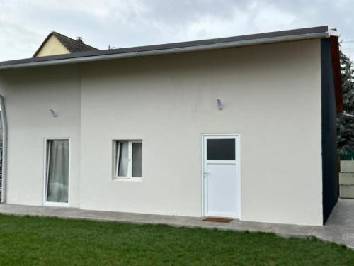 een wit huis met een garage bij Spa_Herrlisheim in Herrlisheim