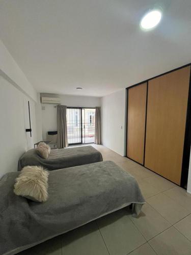 a bedroom with two beds and a large window at Departamento en San Telmo in Buenos Aires