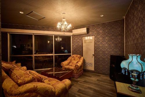 a living room with a couch and a chair at Hotel CABANA カバナ 宮古島 in Miyako Island