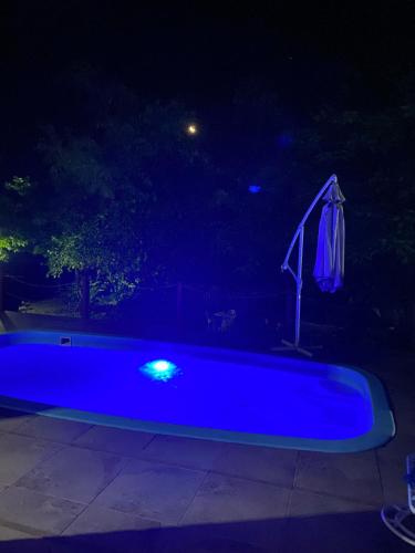 a blue swimming pool at night with an umbrella at Marina Casa de campo in Santa Maria