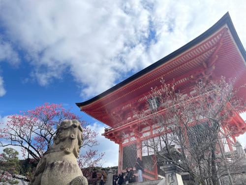 een rood gebouw met een standbeeld ervoor bij HOTEL AMANEK Kyoto Kawaramachi Gojo in Kyoto