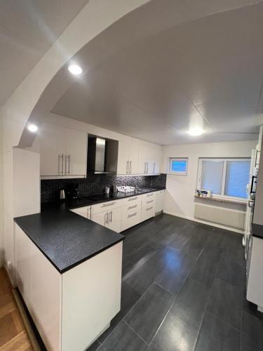 an empty kitchen with white cabinets and a black counter top at Noah Longstay Stratosfärgatan 15 in Gothenburg