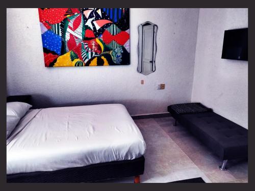 a bedroom with a bed and a painting on the wall at Casa del Pintor Chetumal in Chetumal