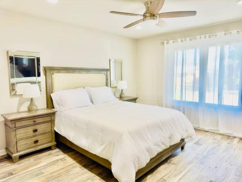 a white bedroom with a bed and a ceiling fan at West Texas Rendezvous in Fort Stockton