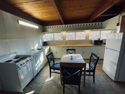 a kitchen with white appliances and a table and chairs at Excelsior at the Manor House in Clemmons
