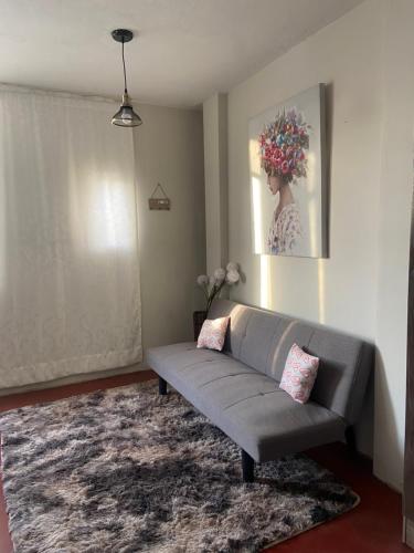 ein Wohnzimmer mit einem Sofa und einem Gemälde an der Wand in der Unterkunft airbnb lima farfalla in Lima