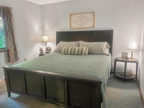 a bedroom with a large bed with two end tables at 2br Lakeside Haven Relax On Long Lake in Gleason