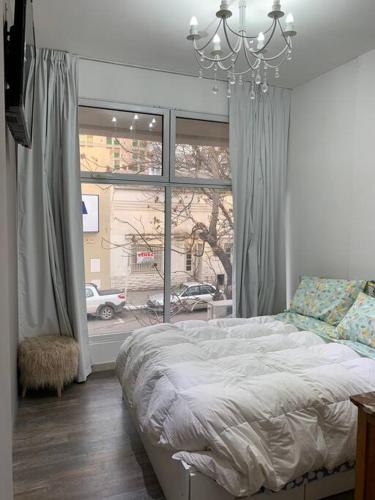 een slaapkamer met een bed en een groot raam bij Hermoso y funcional studio zona consulados. in Bahía Blanca