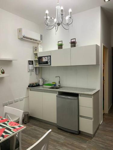 een keuken met witte kasten en een aanrecht bij Hermoso y funcional studio zona consulados. in Bahía Blanca