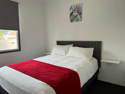 a bedroom with a large bed with a red blanket at Central Boutique Hotel in Oranjestad