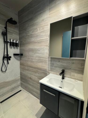 ein Bad mit einem Waschbecken, einem Spiegel und einer Dusche in der Unterkunft Central Boutique Hotel in Oranjestad