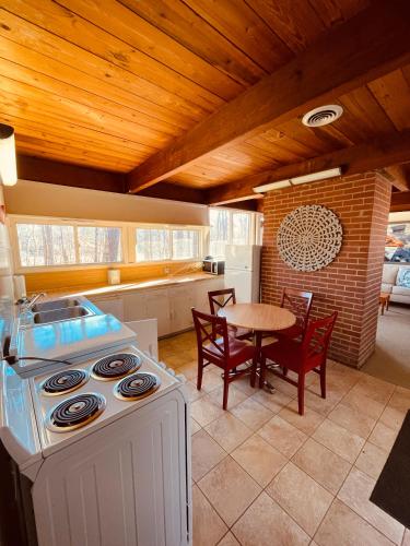a kitchen with a stove and a table with chairs at Excelsior at the Manor House in Clemmons