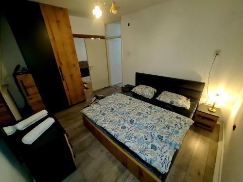 a bedroom with a bed with a blue and white comforter at Apartment for Rent in Gjilan