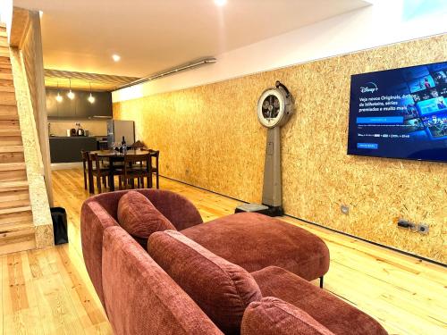 uma sala de estar com sofás e uma televisão na parede em A casa na Estrela em Lisboa