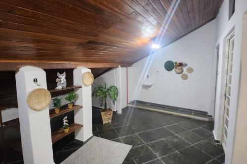 a hallway with a wooden ceiling and a room with plants at CASA DOS SINOS in São João del Rei
