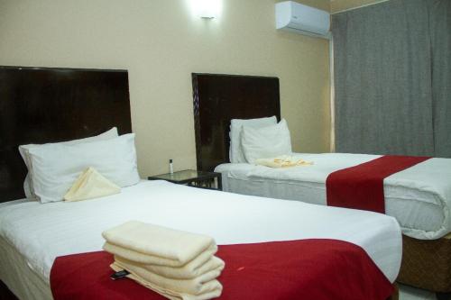 two beds in a hotel room with towels on them at Kamanga Safari Lodge in Maun