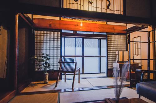 a room with a chair and a large window at A310to 河崎浪漫館 in Sado