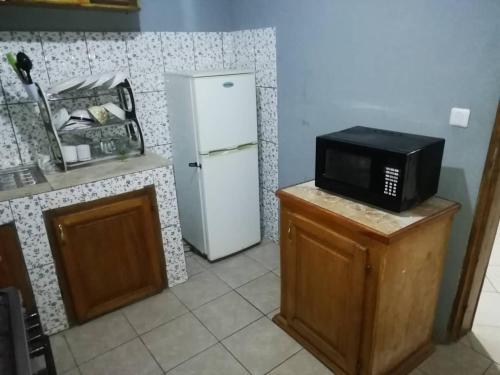 a kitchen with a microwave and a refrigerator at Serenity Place in Limbe