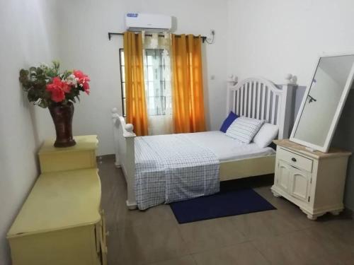 a bedroom with a bed and a dresser with a mirror at Serenity Place in Limbe