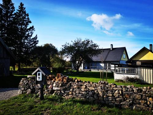 a stone retaining wall in front of a house at Saadumäe Holiday House in Saareküla