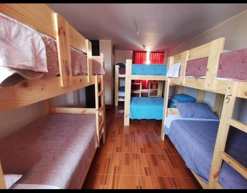 a room with three bunk beds in it at Ohana Hostel in Ica