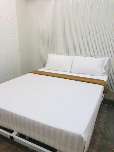 two beds in a room with white sheets and pillows at Rayyaz Inn in Kuala Terengganu