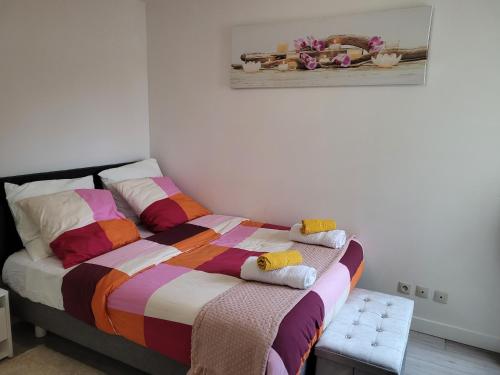 een slaapkamer met een bed met handdoeken erop bij Cocooning House 212 Suite COSY SUNSHINE appartement Aeroport Paris Roissy CDG et Parc Asterix in Survilliers