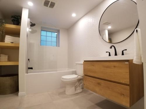 een badkamer met een wastafel, een toilet en een spiegel bij Chalet in the Laurentian Mountains in Sainte-Agathe-des-Monts
