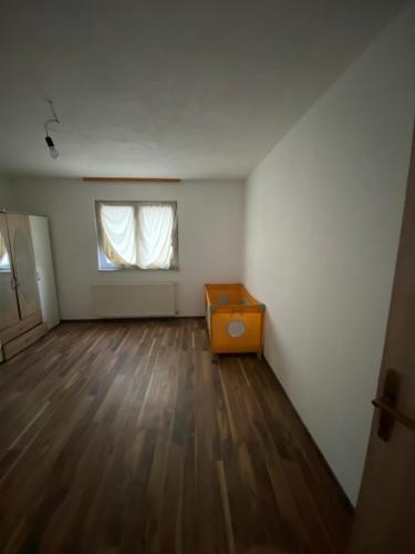 ein leeres Zimmer mit einer Kommode und einem Fenster in der Unterkunft Priroda i društvo in Bosanska Krupa