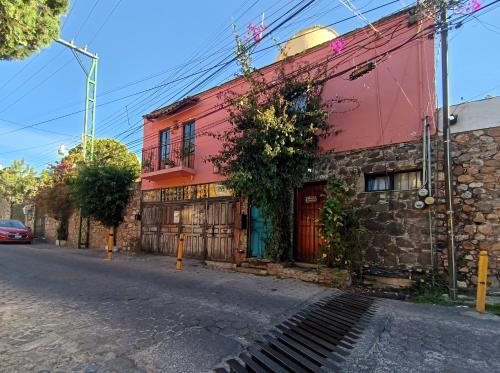 a red building on the side of a street at El Refugio de San Matías in Guanajuato