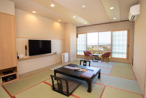a living room with a table and a television at Arima Onsen Motoyu Ryuusenkaku in Kobe