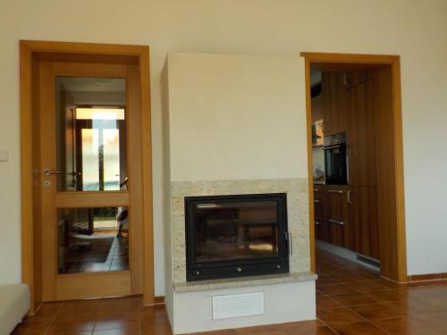 a living room with a fireplace and two doors at Casa Maika in Frymburk