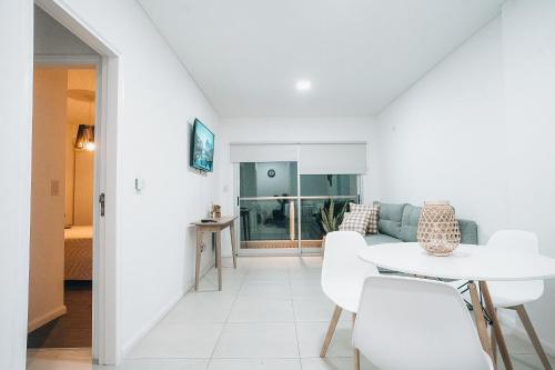 a white living room with a white table and chairs at MI LUGAR * CHIVILCOY in Chivilcoy