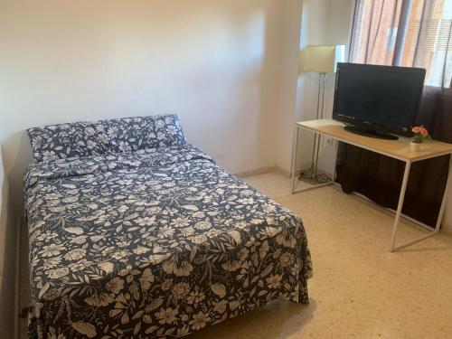 1 dormitorio con 1 cama y escritorio con ordenador en Habitacion en Piso Cerca Playa, en Alicante