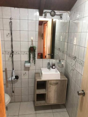 a bathroom with a sink and a mirror at Departamento cerro de la cruz in Punta Arenas