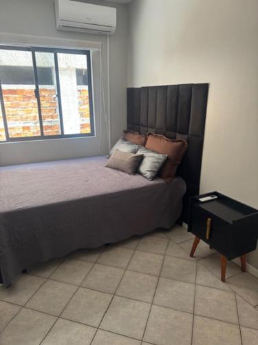 ein Schlafzimmer mit einem großen Bett mit Fenster in der Unterkunft Apartamento na melhor localização da meia praia em itapema com garagem para camioneta suv in Itapema