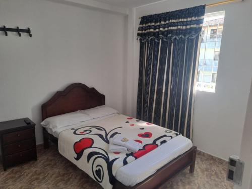 a bedroom with a bed and a window at Hotel Las Dalias in Guatapé