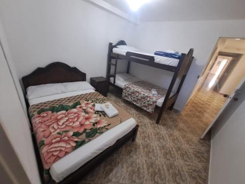 a bedroom with a bed and a bunk bed at Hotel Las Dalias in Guatapé