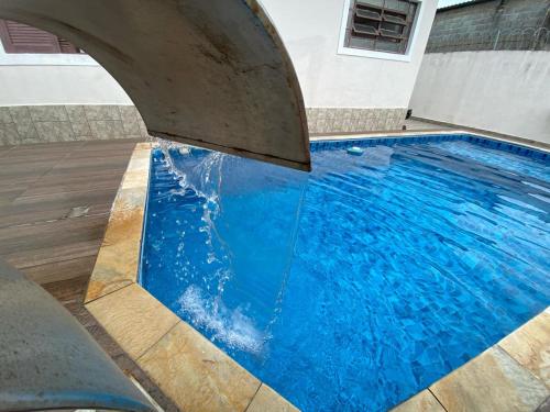 una piscina de agua azul en un edificio en Beach House, en Mongaguá