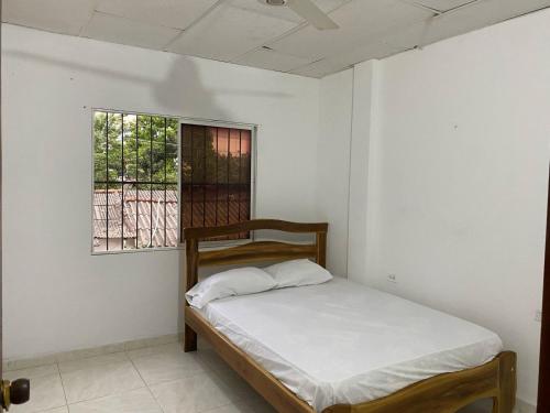 a bed in a room with a window at Donde maga in Mompós