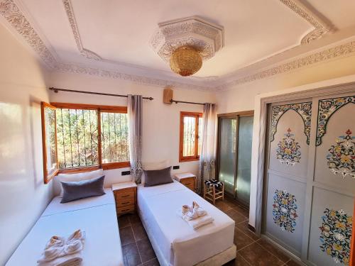 um quarto com 2 camas e uma janela em Villa des étoiles em Ourika