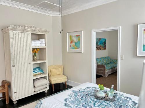 ein Schlafzimmer mit einem Bett, einem Stuhl und einem Spiegel in der Unterkunft Downtown Nassau Oasis Unit 1 in Nassau