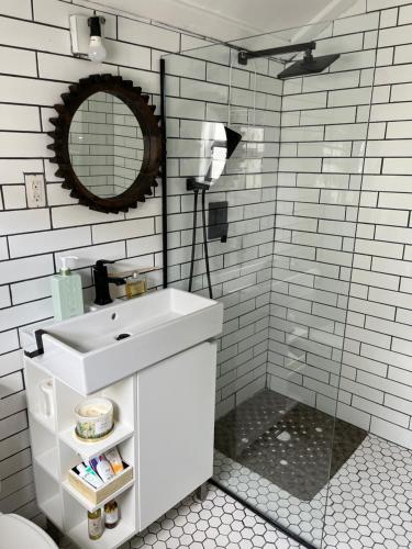 een witte badkamer met een wastafel en een spiegel bij Downtown Nassau Oasis Unit 1 in Nassau