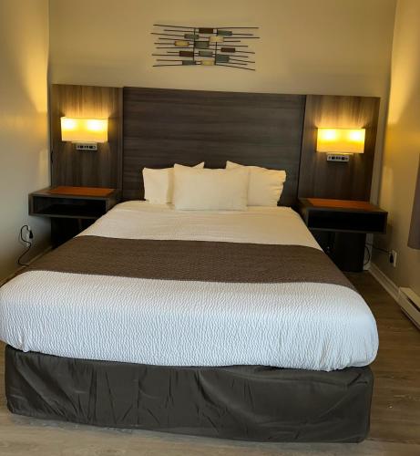 a bedroom with a large bed with two night stands at Lakeview Motel & Cottage in Kincardine