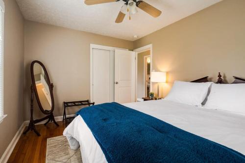 a bedroom with a bed with a blue blanket and a ceiling fan at Colonial Village Retreat 2BR in New Albany