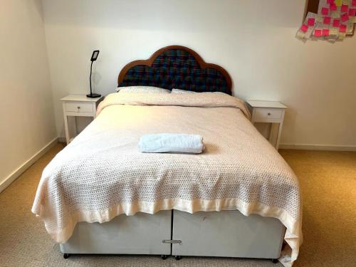 a bedroom with a bed with a towel on it at Spacious Queen Bed City Centre Penthouse With Balcony - Homeshare - Live In Host in Glasgow