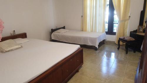 1 dormitorio con 2 camas y ventana en Negombo Lagoon Villa, en Negombo
