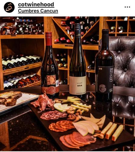a table with two bottles of wine and some food at Suites Athos4 in Cancún